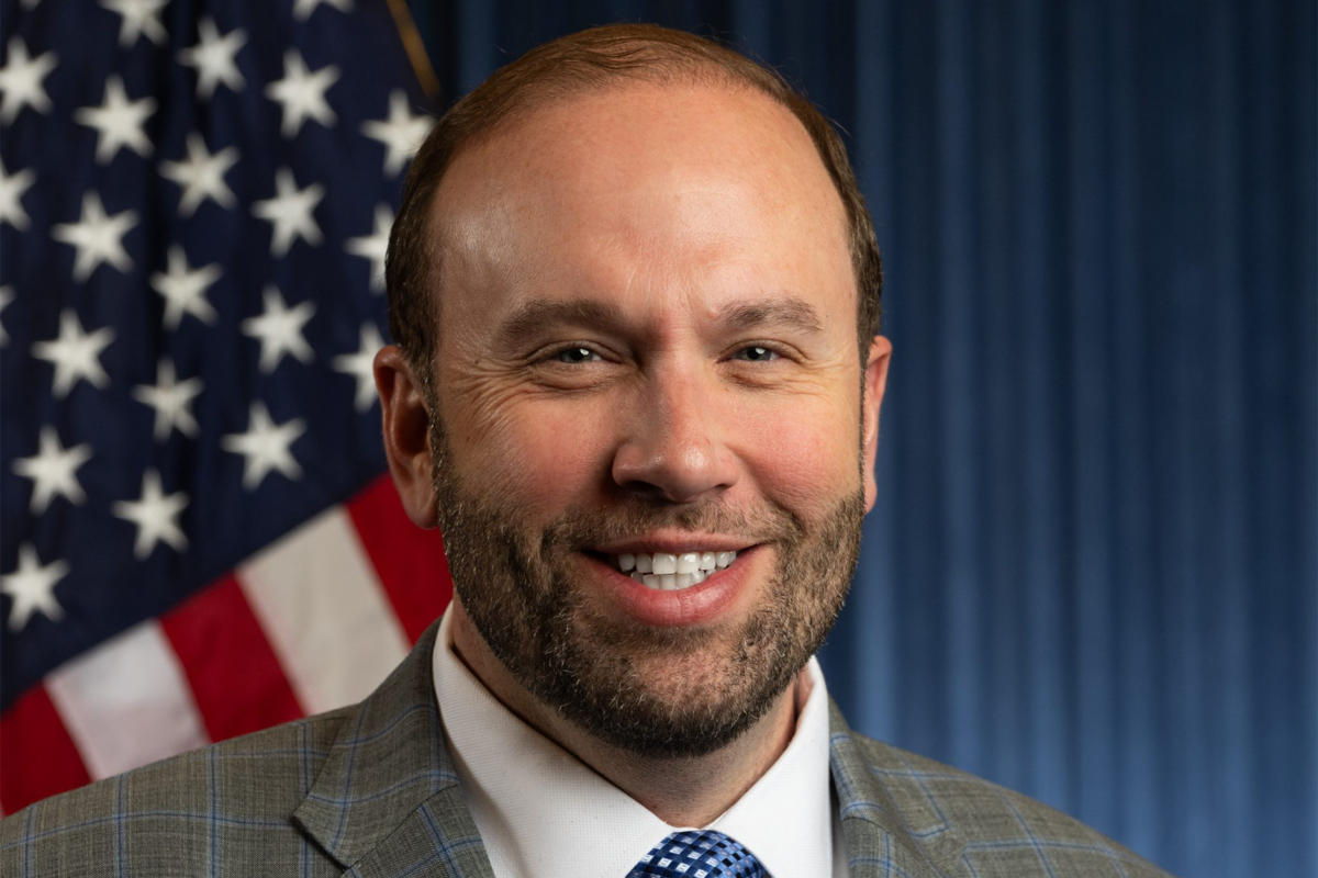 Headshot of Jason Smith with an American flag in the background.